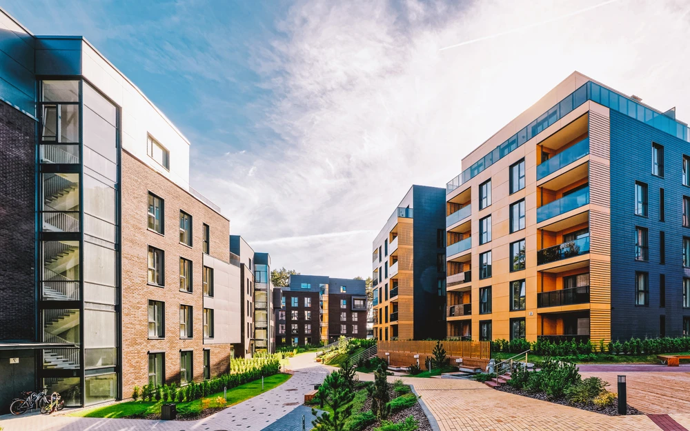 Complexe résidentiel moderne avec immeubles d'appartements de 4-5 étages disposés autour d'une cour paysagée